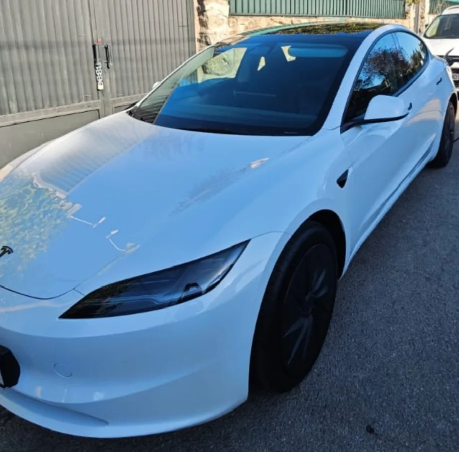 Tesla blanco aparcado en una calle, visto desde la parte delantera